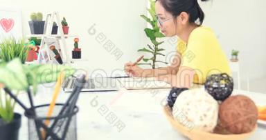 亚洲妇女在家做网上生意。 亚洲妇女正在办公室工作场所处理财务文件。